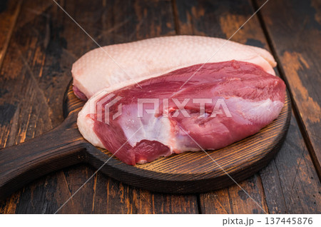 Raw duck breasts skin on and skinless with rosemary and pepper on rustic wooden board ideal for gourmet poultry cooking stock images. 137445876