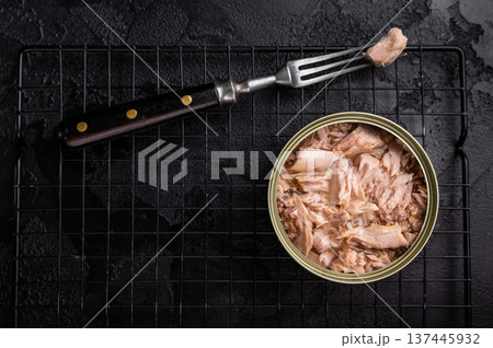 Convenient tinned tuna fillet, perfect for quick meals and packed with protein for a healthy lifestyle. black background. top view Convenient tinned tuna fillet, perfect for quick meals and packed with protein for a healthy lifestyle. black background. top view 137445932