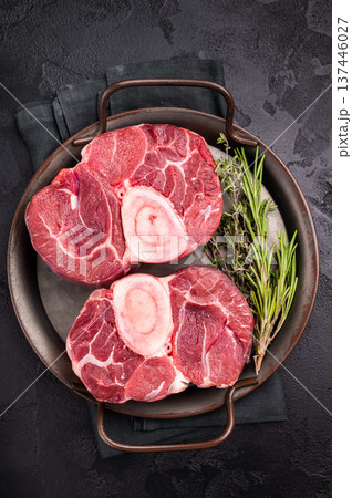 Freshly cross cut shank osso buco, ossobuco meat featuring succulent meat and bone marrow, waiting to elevate your cooking experience. black background. top view 137446027
