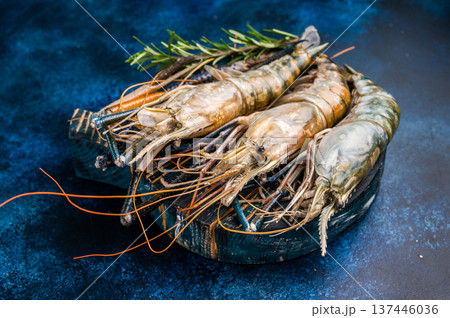 Uncooked rosenbergii fresh water shrimp ready for preparation, perfect for chefs looking to create exquisite seafood dishes. blue background. top view 137446036
