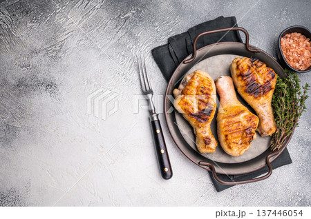 Juicy grilled chicken drumsticks, perfectly charred and bursting with flavor, ideal for a summer barbecue. grey background. top view Juicy grilled chicken drumsticks, perfectly charred and bursting with flavor, ideal for a summer barbecue. grey background. top view 137446054