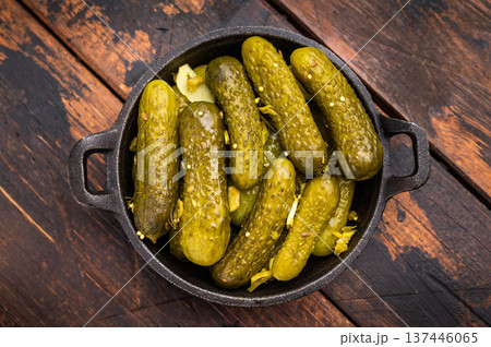 Artisan Pickled Gherkins, pickled cucumbers, beautifully arranged and ready to elevate your culinary creations with their bold taste. wooden background. top view 137446065