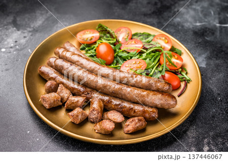 Close up of perfectly charred grilled sausage with salad, ideal for adding flavor to your favorite dishes or sandwiches. black background. top view Close up of perfectly charred grilled sausage with salad, ideal for adding flavor to your favorite dishes or sandwiches. black background. top view 137446067