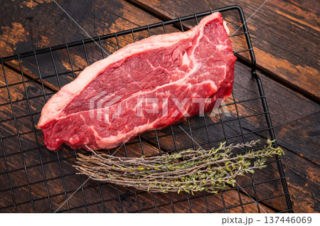 High quality raw striploin steak ready for seasoning, perfect for crafting the ultimate steak dinner experience. wooden background. top view High quality raw striploin steak ready for seasoning, perfect for crafting the ultimate steak dinner experience. wooden background. top view 137446069