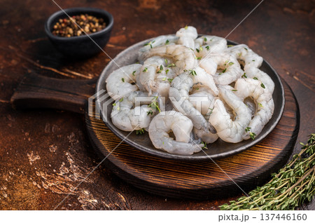 Raw peeled shrimp prawn in a cast iron skillet on a dark rustic wood background. Overhead shot with copy space and spices. 137446160