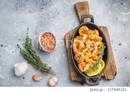 Ready-to-eat pan-seared shrimp (prawns) with fresh herbs, positioned for an advertisement or a clean, modern food magazine layout. 137446162