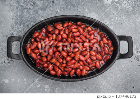 Kidney beans in a cast iron skillet on a rustic wooden board. Large gray copy space for text. Overhead, minimal style. 137446172