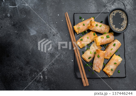 Crispy fried spring rolls Lumpia on slate plate with soy sauce sesame chopsticks and copy space top view Crispy fried spring rolls Lumpia on slate plate with soy sauce sesame chopsticks and copy space top view 137446244