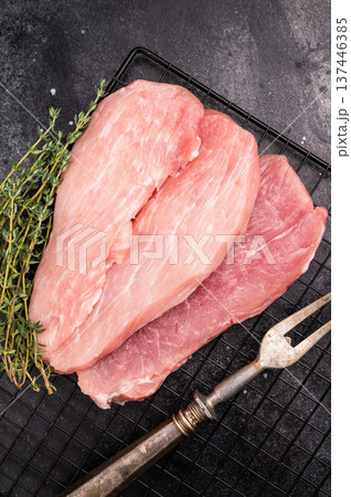 Raw pork fillet meat for schnitzel, steaks on a rack. black background. top view 137446385