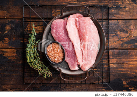 Freah Raw pork fillet for schnitzel, tenderloin meat in a steel tray. Wooden background. top view Freah Raw pork fillet for schnitzel, tenderloin meat in a steel tray. Wooden background. top view 137446386