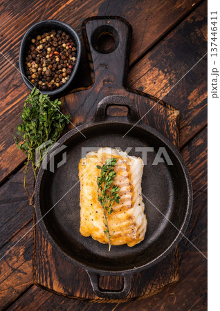 Roasted cod fish loin fiilet in skillet. Wooden background. top view Roasted cod fish loin fiilet in skillet. Wooden background. top view 137446411