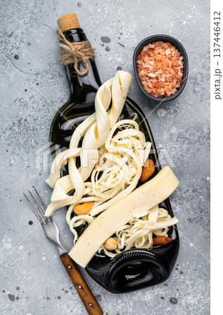 Cheese board with assortment of Chechil white cheese with nuts, gray background. 137446412
