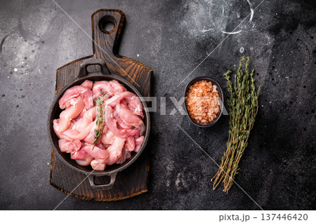 Raw Chicken sliced thighs fillets in a skillet. black background. top view Raw Chicken sliced thighs fillets in a skillet. black background. top view 137446420