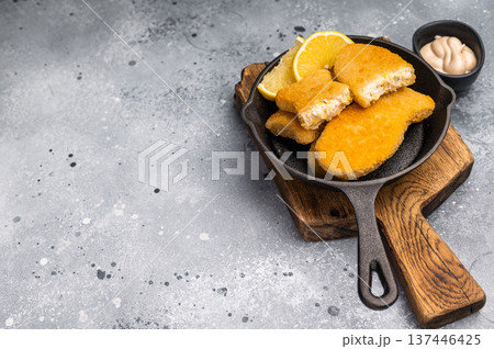 Breaded gold Fish sticks in pan. grey background. top view 137446425