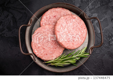 Freshly formed raw meat patty with herbs for burgers, perfect for grilling or frying to satisfy your cravings. black background. top view Freshly formed raw meat patty with herbs for burgers, perfect for grilling or frying to satisfy your cravings. black background. top view 137446475