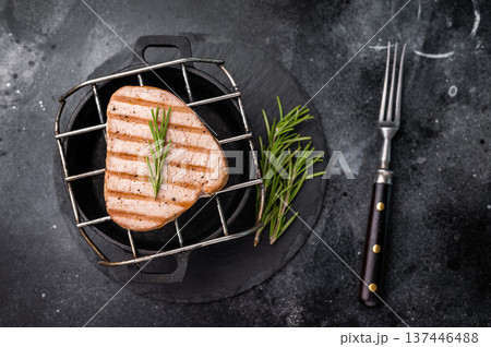 Juicy grilled tuna steak, perfectly seared with a smoky flavor, ideal for seafood lovers and gourmet dishes. black background. top view 137446488