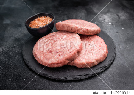 Fresh raw beef meat patty ready for grilling, perfect for homemade burgers and delicious family meals.black background. top view 137446515