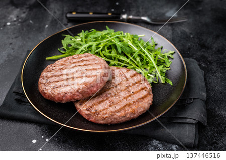 Grilled beef and pork meat patty paired with fresh veggies, an essential component for gourmet burgers. black background. top view 137446516