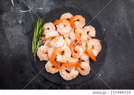 A plate of shrimp with a sprig of rosemary on top. The shrimp are arranged in a way that they are not overlapping each other. 137446534