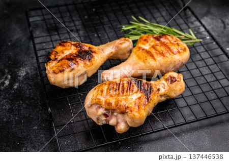Savory BBQ chicken legs, drumsticks beautifully caramelized on the grill, ready to be enjoyed with your favorite dipping sauce. black background. top view Savory BBQ chicken legs, drumsticks beautifully caramelized on the grill, ready to be enjoyed with your favorite dipping sauce. black background. top view 137446538