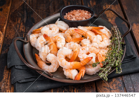 A plate of shrimp with a black bowl of salt and pepper. The shrimp are arranged in a way that they look like they are ready to be eaten A plate of shrimp with a black bowl of salt and pepper. The shrimp are arranged in a way that they look like they are ready to be eaten 137446547