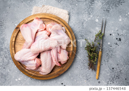 Fresh raw chicken wings, perfect for marinating and grilling, ready to become the star of your next barbecue. grey background. top view Fresh raw chicken wings, perfect for marinating and grilling, ready to become the star of your next barbecue. grey background. top view 137446548