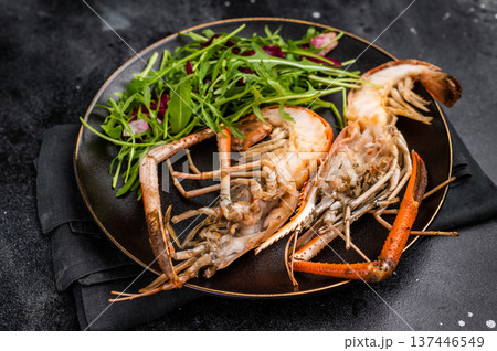 Elegant plate of grilled rosenbergii prawns shrimps garnished with fresh herbs, perfect for gourmet dining experiences. black background. top view 137446549