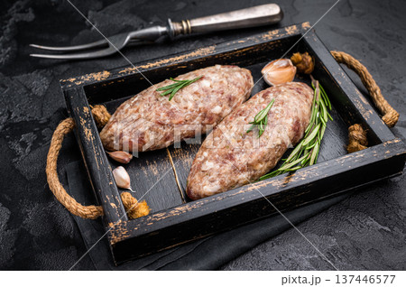 Raw kebabs or kabaps on wooden tray, beautifully arranged and ready to be cooked for a delicious outdoor feast. black background. top view 137446577