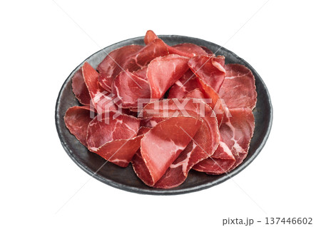 Thin cured beef slices cecina arranged on a dark plate over a clean white background, creating a minimal gourmet look. Thin cured beef slices cecina arranged on a dark plate over a clean white background, creating a minimal gourmet look. 137446602