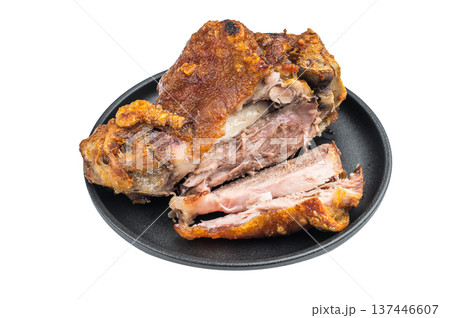 Sliced roasted pork knuckle showing crispy crackling rind and juicy fibrous meat structure on black plate against clean white background. 137446607