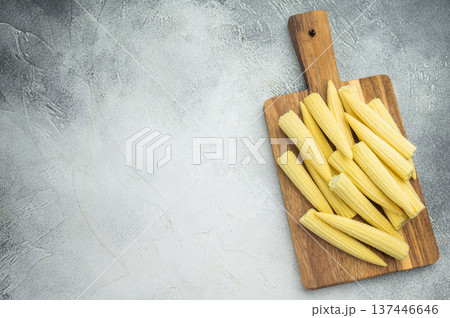 Raw baby corn maize arranged on rustic chopping board top view with copy space ideal for vegetarian recipes and asian cuisine concepts 137446646