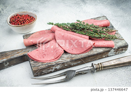 Thin slices of Turkish beef salam on rustic wood with thyme and pepper on bright textured background ideal for deli and food stock use. 137446647