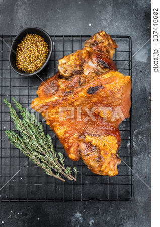 Oven roasted pork shank showing crispyskin, seared surface and gelatin rich structure served on grillrack with aromatic herbs and spices. Oven roasted pork shank showing crispyskin, seared surface and gelatin rich structure served on grillrack with aromatic herbs and spices. 137446682