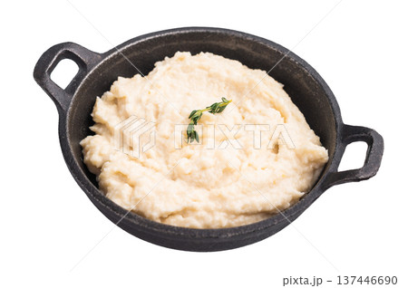 Creamy horseradish sauce in a rustic black cast iron bowl, garnished with a fresh sprig of thyme. Isolated on white background. 137446690
