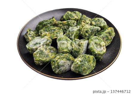 Green, icy spinach portions ready for cooking, served in a rustic black bowl. Concept of healthy eating and food storage. 137446712