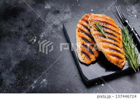 Grilled chicken breasts steaks with rosemary, farm poultry meat, top view, black background. 137446724