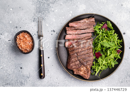 Barbecue dry aged wagyu entrecot steak on plate with salad. grey background. top view Barbecue dry aged wagyu entrecot steak on plate with salad. grey background. top view 137446729