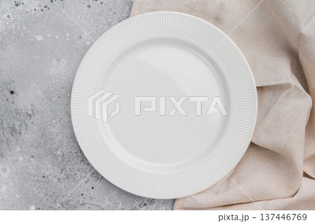 Empty white ceramic plate on gray concrete background with linen cloth. Minimal tableware mockup with copy space 137446769