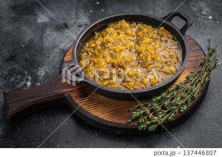 Homemade cucumber relish condiment in cast iron pan on rustic wooden board dark stone background overhead view 137446807