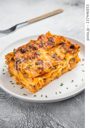 Homemade beef lasagna slice with rich meat sauce pasta sheets and cheesy crust served on white plate Homemade beef lasagna slice with rich meat sauce pasta sheets and cheesy crust served on white plate 137446853