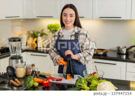 Woman grating fresh carrot on kitchen grater for healthy salad or smoothie preparation at home Woman grating fresh carrot on kitchen grater for healthy salad or smoothie preparation at home 137447154