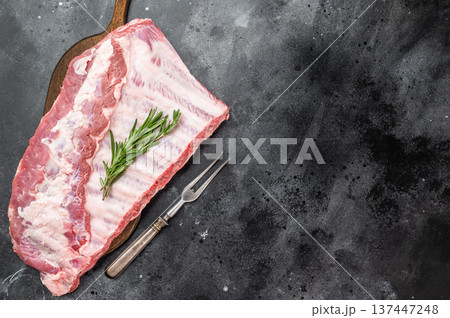 Pork spareribs raw whole rack with rosemary on cutting board overhead view meat ingredient for grill smoking and roasting Pork spareribs raw whole rack with rosemary on cutting board overhead view meat ingredient for grill smoking and roasting 137447248