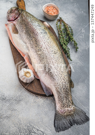 Whole raw rainbow trout on wooden board with knife salt garlic and herbs flat lay on stone background with copy space Whole raw rainbow trout on wooden board with knife salt garlic and herbs flat lay on stone background with copy space 137447249