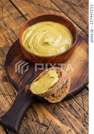 Sweet pistachio cream spread on bread with wooden bowl and knife overhead view rustic breakfast concept with copy space Sweet pistachio cream spread on bread with wooden bowl and knife overhead view rustic breakfast concept with copy space 137447253