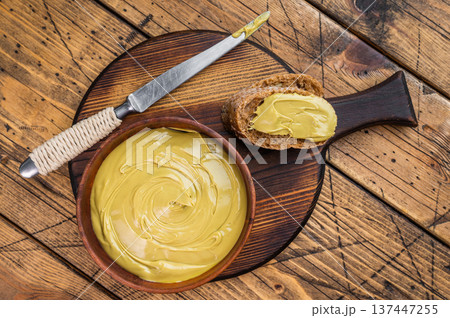 Sweet pistachio cream spread on bread with wooden bowl and knife overhead view rustic breakfast concept with copy space 137447255