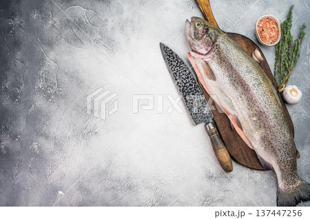 Fresh whole trout fish with knife and spices rustic seafood preparation concept on gray stone background Fresh whole trout fish with knife and spices rustic seafood preparation concept on gray stone background 137447256