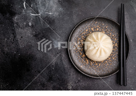 Chinese Steam Bao bun with meat on plate with chopsticks. black background. top view 137447445