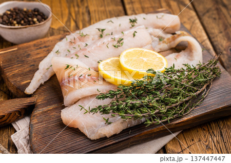 Haddock sea fish fillets, raw whitefish on a wooden board ready for cooking. wooden background. top view 137447447