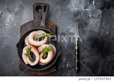Ready for cooking Raw Pollock fish fillets in pan with herbs. black background. top view 137447463