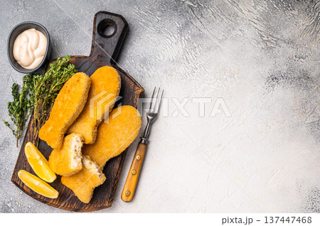 Deep fried Fish fingers on wooden board. white background. top view 137447468